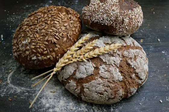 Artisan sourdough loaves with wheat stalks on a bakery counter
