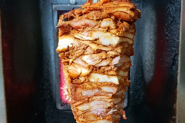 Shawarma roasting on a vertical grill